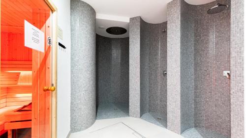 uma casa de banho com um chuveiro com paredes em azulejos cinzentos em Apartamenty Good Time - Stone Hill III em Szklarska Poręba