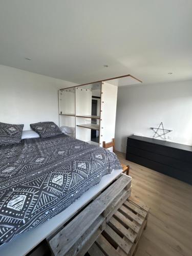 1 dormitorio con 1 cama grande y suelo de madera en Villa piscine, jardin et tranquillité, en Saint-Étienne