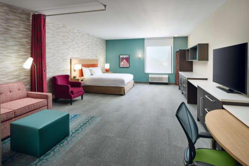 リッチモンドにあるHome2 Suites By Hilton Richmond Glensideのベッドとテレビがあるホテルの部屋