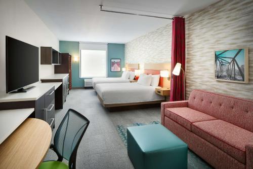 a hotel room with a bed and a couch at Home2 Suites By Hilton Richmond Glenside in Richmond