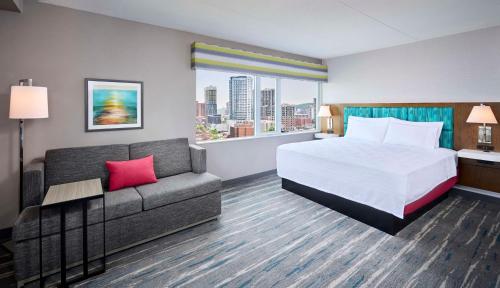 um quarto de hotel com uma cama e um sofá em Hampton Inn By Hilton Hamilton em Hamilton