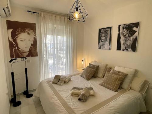 - un grand lit blanc dans une chambre avec des photos sur le mur dans l'établissement Málaga casa grande familiar, à Malaga