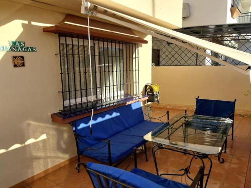 a balcony with a table and chairs and a bird cage at Málaga casa grande familiar in Málaga