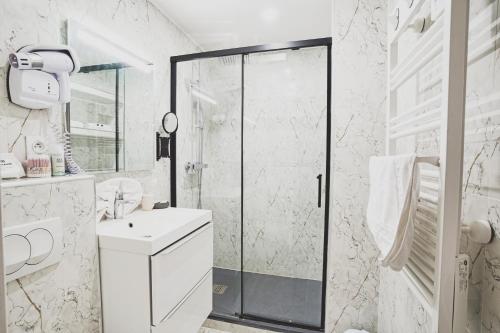uma casa de banho branca com um chuveiro e um lavatório. em Cosy Aulnay- Paris Nord-Expo Villepinte em Aulnay-sous-Bois
