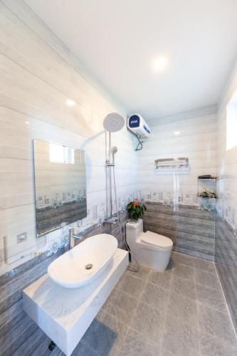 a bathroom with a white sink and a toilet at Trà My Villa Đà Lạt BBQ Garden in Da Lat