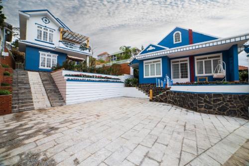 a blue and white house with a driveway at Trà My Villa Đà Lạt in Da Lat
