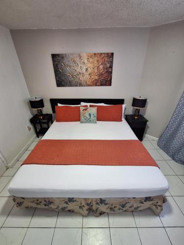 um quarto com uma cama grande e almofadas vermelhas em Beach One Bedroom 2 em Ocho Rios