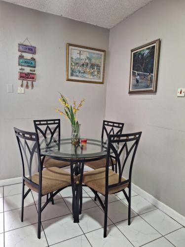 a dining room with a glass table and chairs at Beach One Bedroom 2 in Ocho Rios
