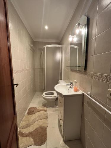 a bathroom with a sink and a toilet and a mirror at Appartement rooftop face à la mer in Apúlia