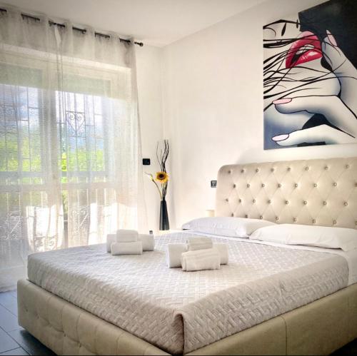 Residenza stadio في تورينو: غرفة نوم بسرير كبير عليها لوحة على الحائط
