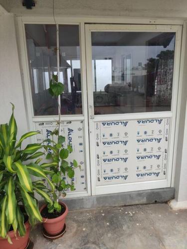 a store door with two potted plants in front of it at a 1bhk full service appartment entire house in Bangalore