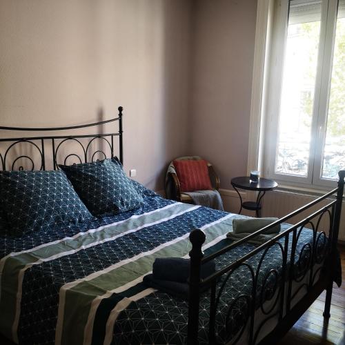 une chambre avec un lit avec une couette bleue dans l'établissement Appartement Cosy, à Saint-Étienne