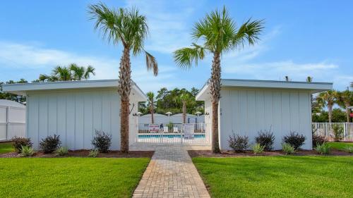 a house with two palm trees in a yard at Boho Beach House in Inlet Beach
