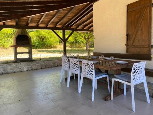 une table et des chaises en bois sur une terrasse dans l'établissement Peaceful gîte with stunning pool near market town, à Montaigu-de-Quercy