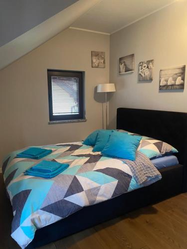 a bedroom with a bed with a colorful comforter at Hire House in Pobierowo