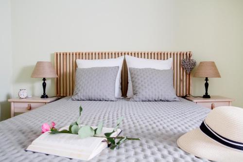 a bed with two books and a hat and two lamps at Casa da Avó Guilhermina in Leiria