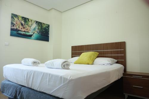 1 dormitorio con 1 cama grande y toallas. en The Great Valencia Stay en Valencia