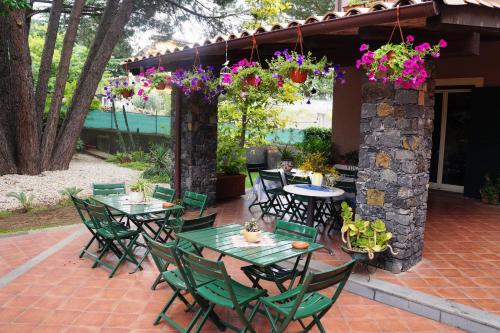 een patio met tafels, stoelen en bloemen bij Rosso Vulcano in Nicolosi