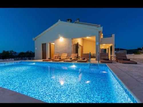 a large swimming pool in front of a house at Vila Vanessa Trogir - Čiovo in Trogir