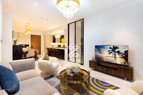 a living room with a couch and a tv at THE CREST-Central Saigon Riverside -Free POOL-GYM-SAUNA Room-YOGA Room in Ho Chi Minh City