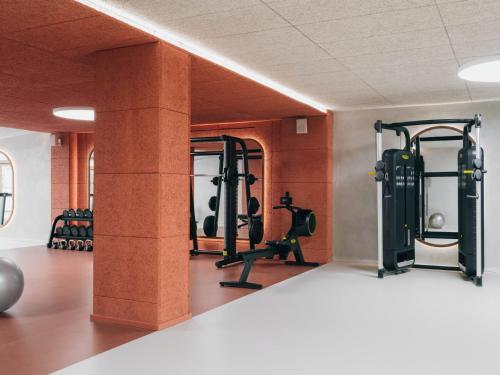a gym with two columns and tread machines at Mondrian Ibiza in Cala Llonga