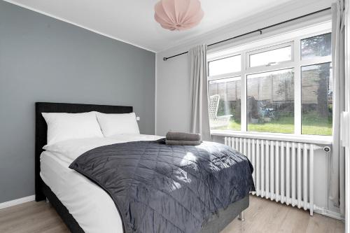 1 dormitorio con cama y ventana grande en Lali Full Apartment en Reikiavik
