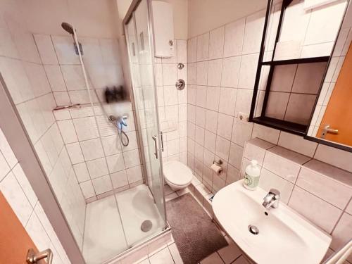 a bathroom with a shower and a toilet and a sink at The Room - Direkt in der Stadt! in Bochum
