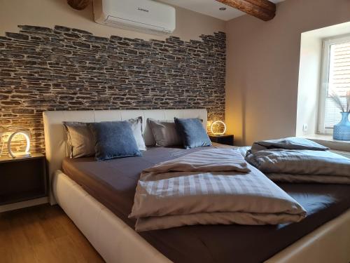 2 camas en un dormitorio con una pared de ladrillo en Ferienhaus Nißmitz No.32, en Freyburg