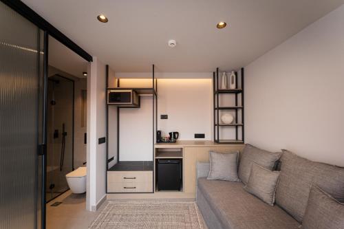 a living room with a couch and a kitchen at Navria by Aetoma in Nafplio