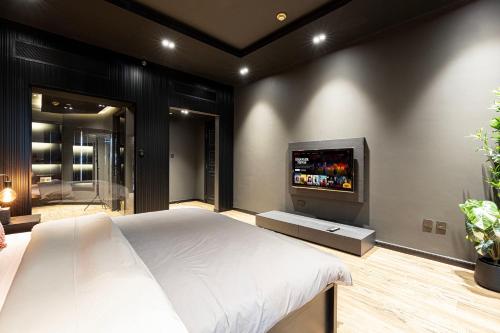 a bedroom with a bed and a flat screen tv at Poetry of the Shadows by Lagom in Dubai