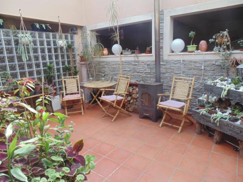 eine Terrasse mit Stühlen, einem Tisch und einem Kamin in der Unterkunft Quarto duplo em Foros de Salvaterra in Estanqueiro