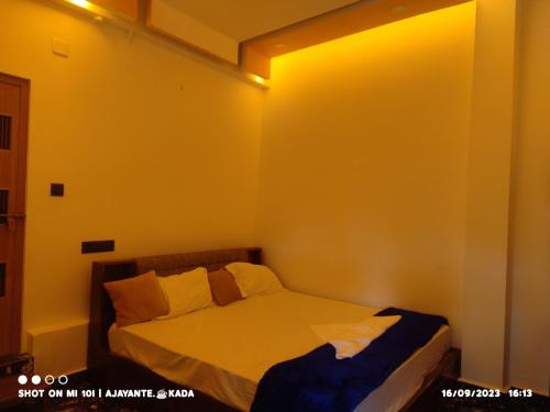 een slaapkamer met een bed met een gele muur bij Naturehive in Idukki