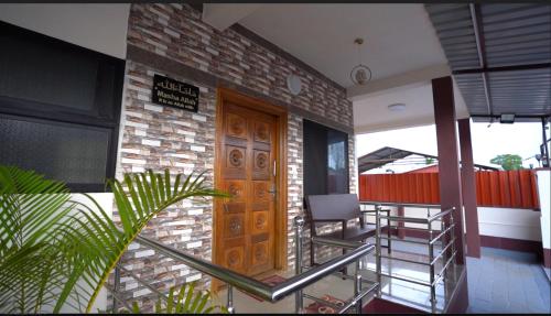 a porch with chairs and a wooden door on a house at UDUPI HOMESTAY - Hill Top Villa in Udupi