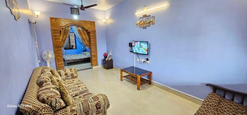 a living room with a couch and a tv at UDUPI HOMESTAY - Hill Top Villa - Dendoorkatte in Udupi