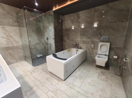 a bathroom with a tub and a toilet and a shower at Oro Montana Hotels and Resort in Gangtok