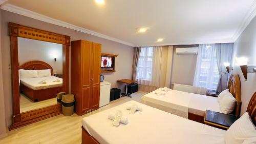 Habitación de hotel con 2 camas y un espejo grande. en Taksim Centre Hotel en Estambul