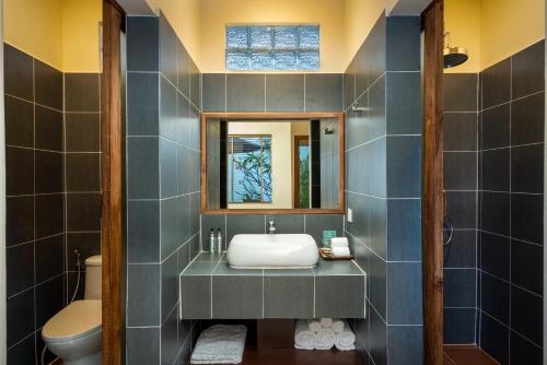 ein Badezimmer mit Waschbecken und Spiegel in der Unterkunft Amatak Boutique Hotel in Siem Reap
