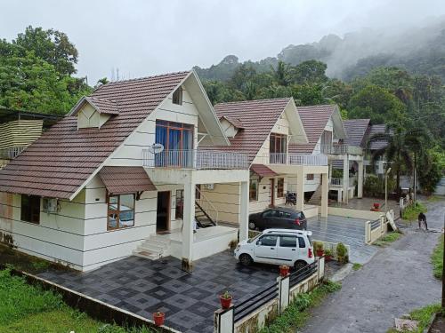 a house with a car parked in front of it at RAIN DROPS PREMIUM VILLAS - Athirappilly in Athirappilly