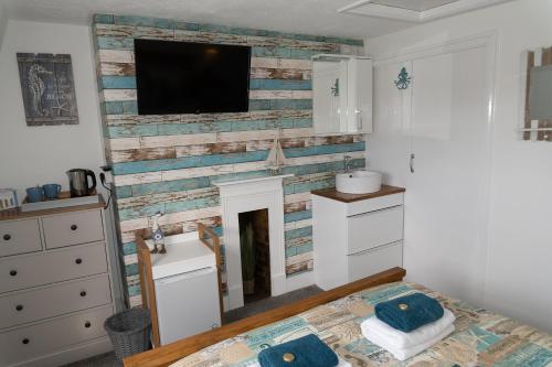 a bedroom with a fireplace with a tv above it at Seacrest Guest House in Weymouth