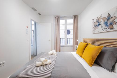 sypialnia z dużym łóżkiem z żółtymi poduszkami w obiekcie Nordik Apartments Urban - Centro "Oslo" w Maladze
