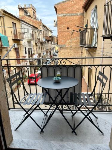 a table and two chairs on a balcony at THE PALACE B&B and Apartments in Santo Stefano di Camastra