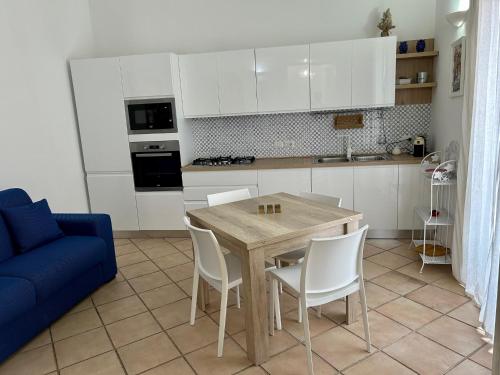 a kitchen with a table and chairs and a blue couch at THE PALACE B&B and Apartments in Santo Stefano di Camastra