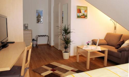 a living room with a couch and a table at Hotel Am Wintergarten in Bocholt