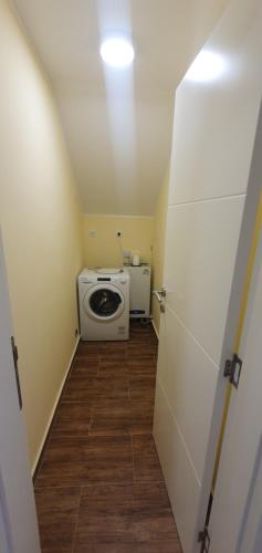 een kleine kamer met een wasmachine en een deur bij Apartman Queen in Pasuljište