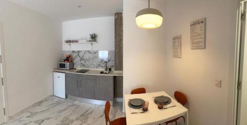 a small kitchen with a table and chairs at Apartamento Centro Victor o Victoria in Úbeda