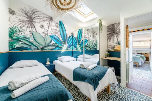 deux lits dans une chambre avec une fresque de plantes dans l'établissement Casa Azul - magnifique duplex coeur historique 4 chambres avec terrasse vue mer, à La Ciotat