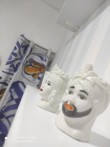 two white masks sitting on top of a table at DA FEDERICA Casa Vacanze BAIA PORTO DELLE GENTI in Lipari