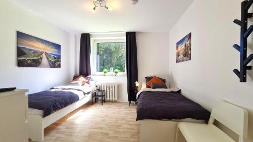 a bedroom with two beds and a window at Perfect Apartment in Unna close to Dortmund in Unna