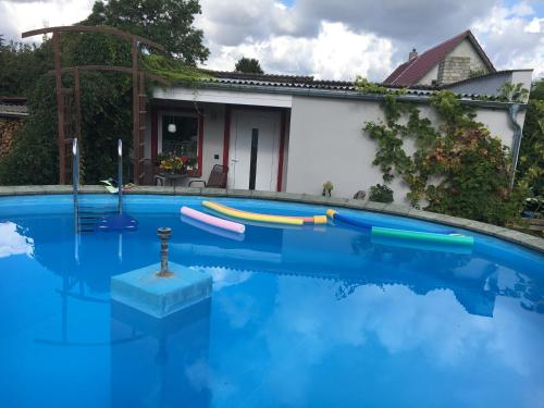 uma piscina com água azul em frente a uma casa em idyllisches Ferienhäuschen em Lansen
