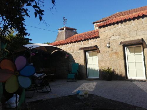 a stone building with a patio and a house at Casa Rústica com Piscina Privada - Perto do Porto in Landim